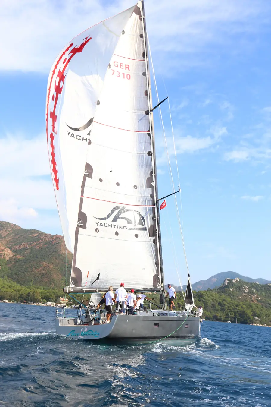 A sailing yacht and crew under sail