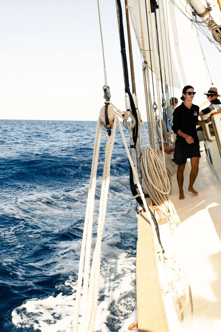 Sailors on deck beside the sails and rigging